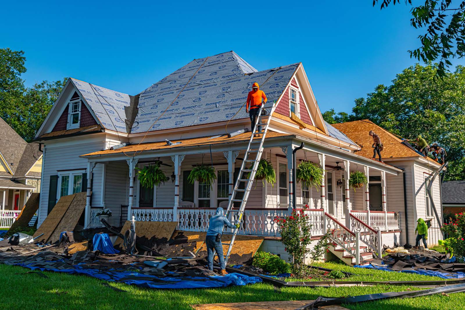 Roofers replacing the roof of an older house