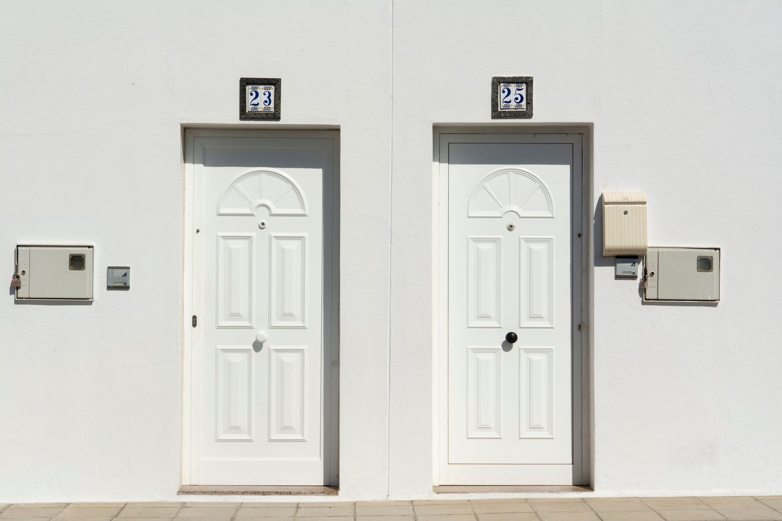 Two white front doors side by side with unit numbers