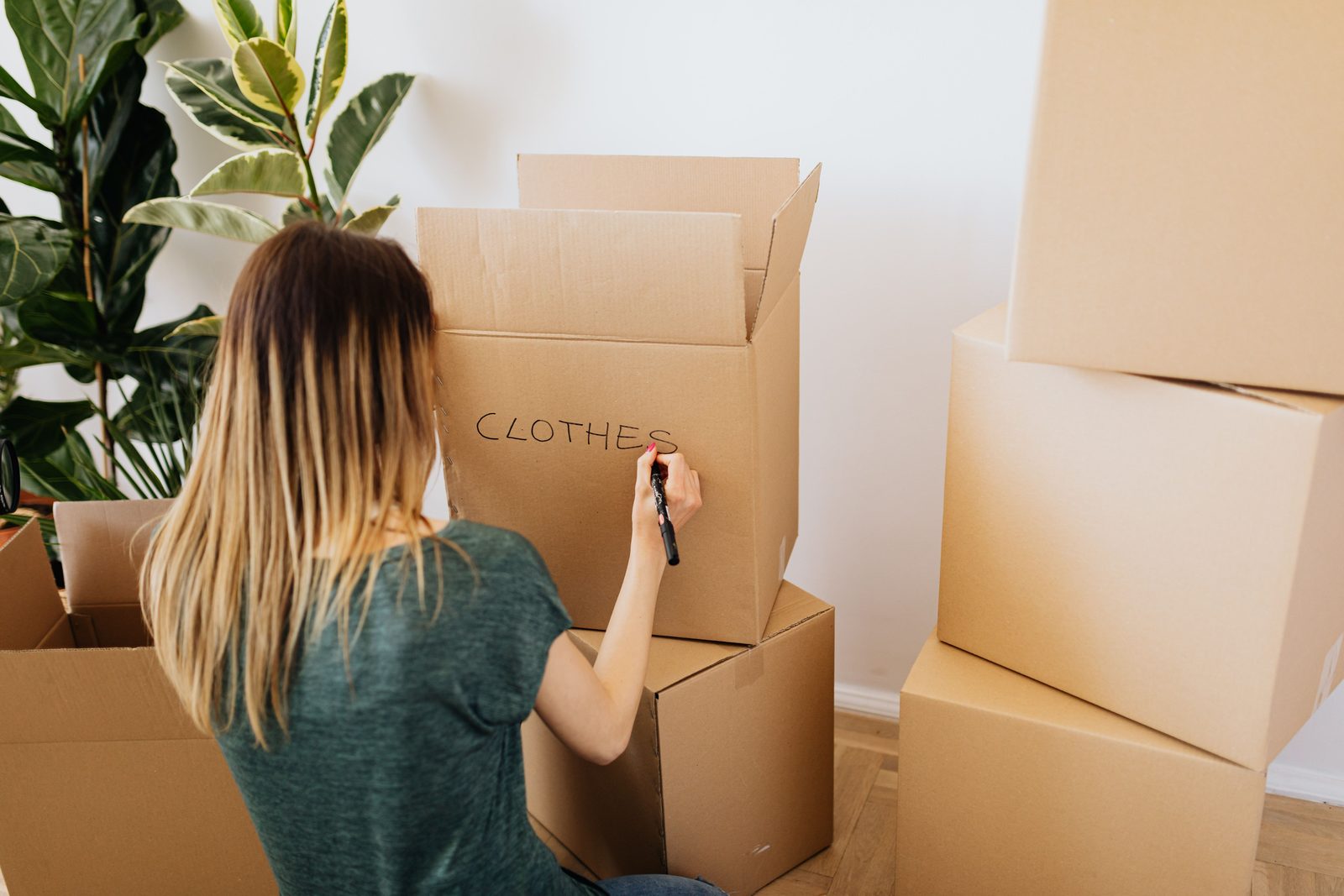 Person writing on a moving box while packing